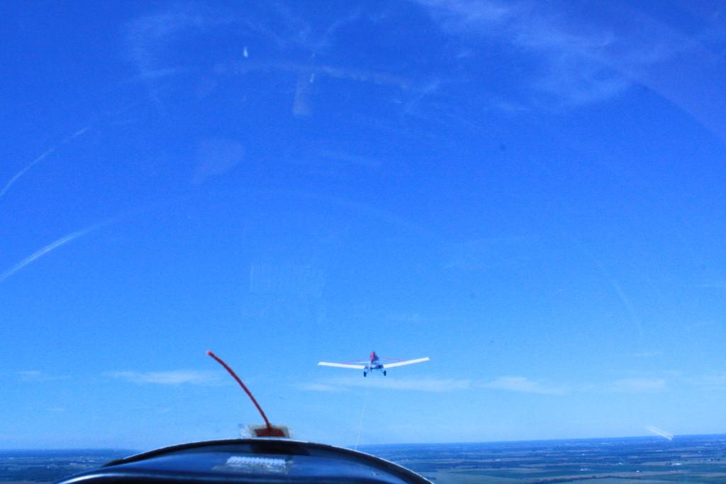 This photo was taken inside of a glider plane.  A glider is a plane that has no engine.  The process involves another plane pulling the glider into the air and once the glider reaches an altitude of about 30,000 feet, it disconnects from the other plane and stays in the air for about half an hour and then safely glides back down to the ground.  This photo was taken while the glider plane was being pulled into the air. 