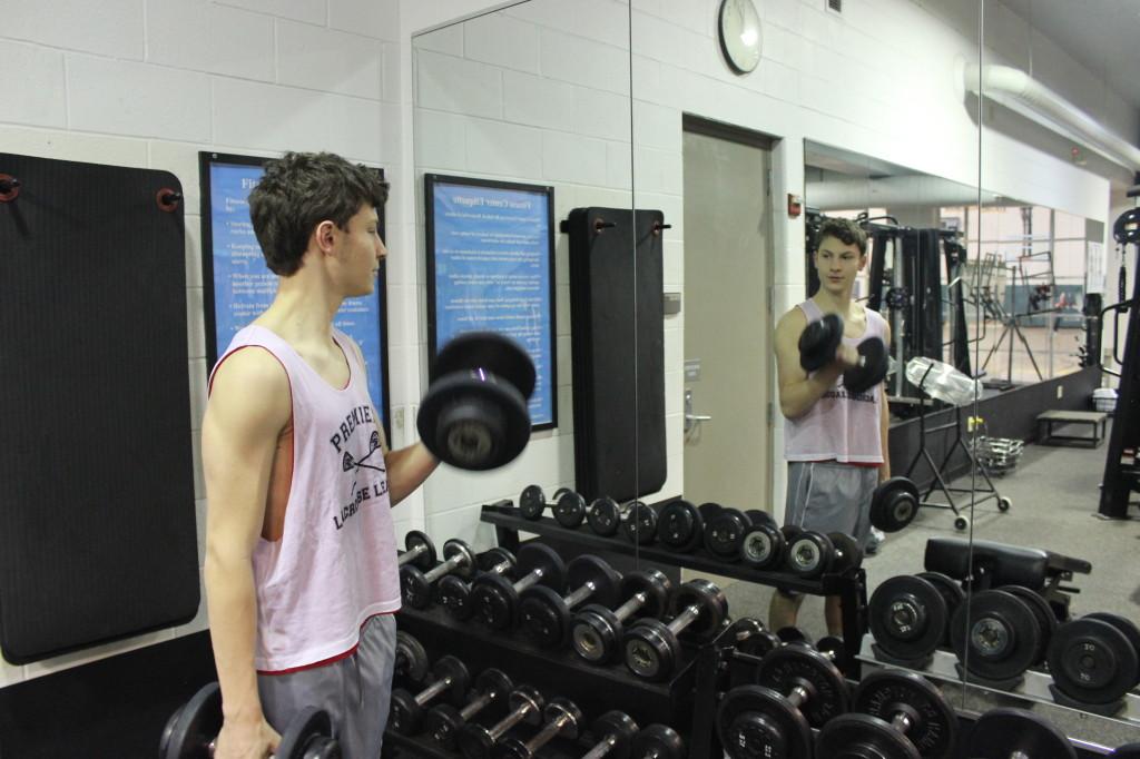 A student lifts weights (Abraham Bluestone)