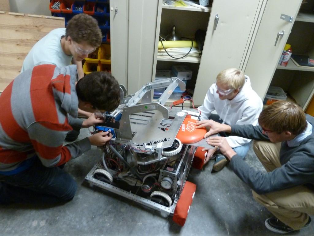 The CHS robotics team tools with last year's robot. The 2013 robot was capable of throwing a frisbee (Photo by Andrew Erblich).