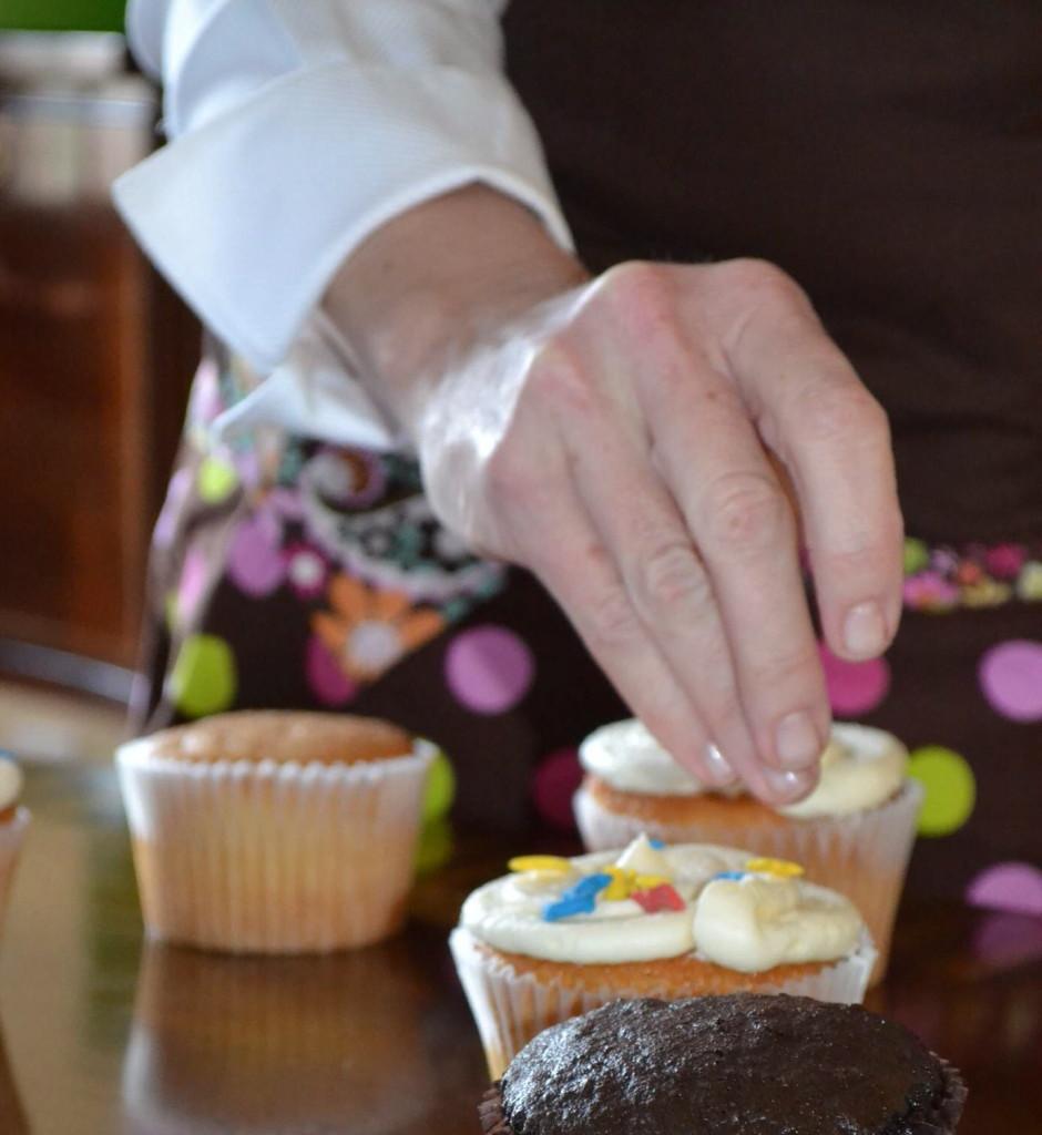 Sweetology co-founder adds sprinkles to cupcake. (Beatrice Engel)