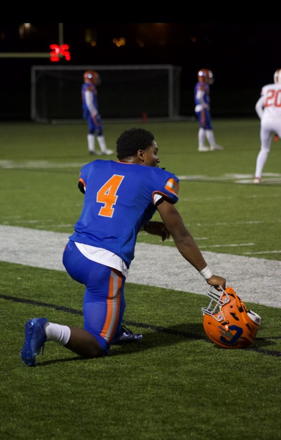 A CHS football player rests on the sideline. 