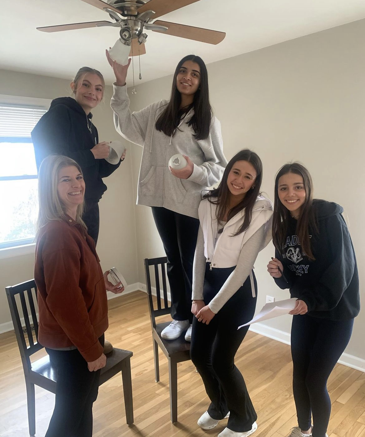 Senior Aanya Singh works with other interns to fix a light bulb on one of her real-estate agents properties