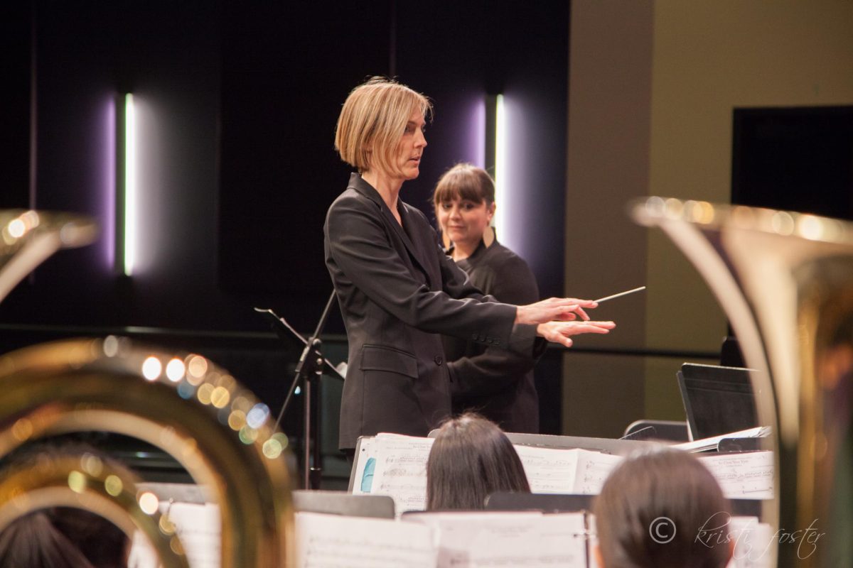 Baton raised, Jennifer Shenberger looks into the crowd of her middle school symphonic band, awaiting the down-beat of one of their pieces.
