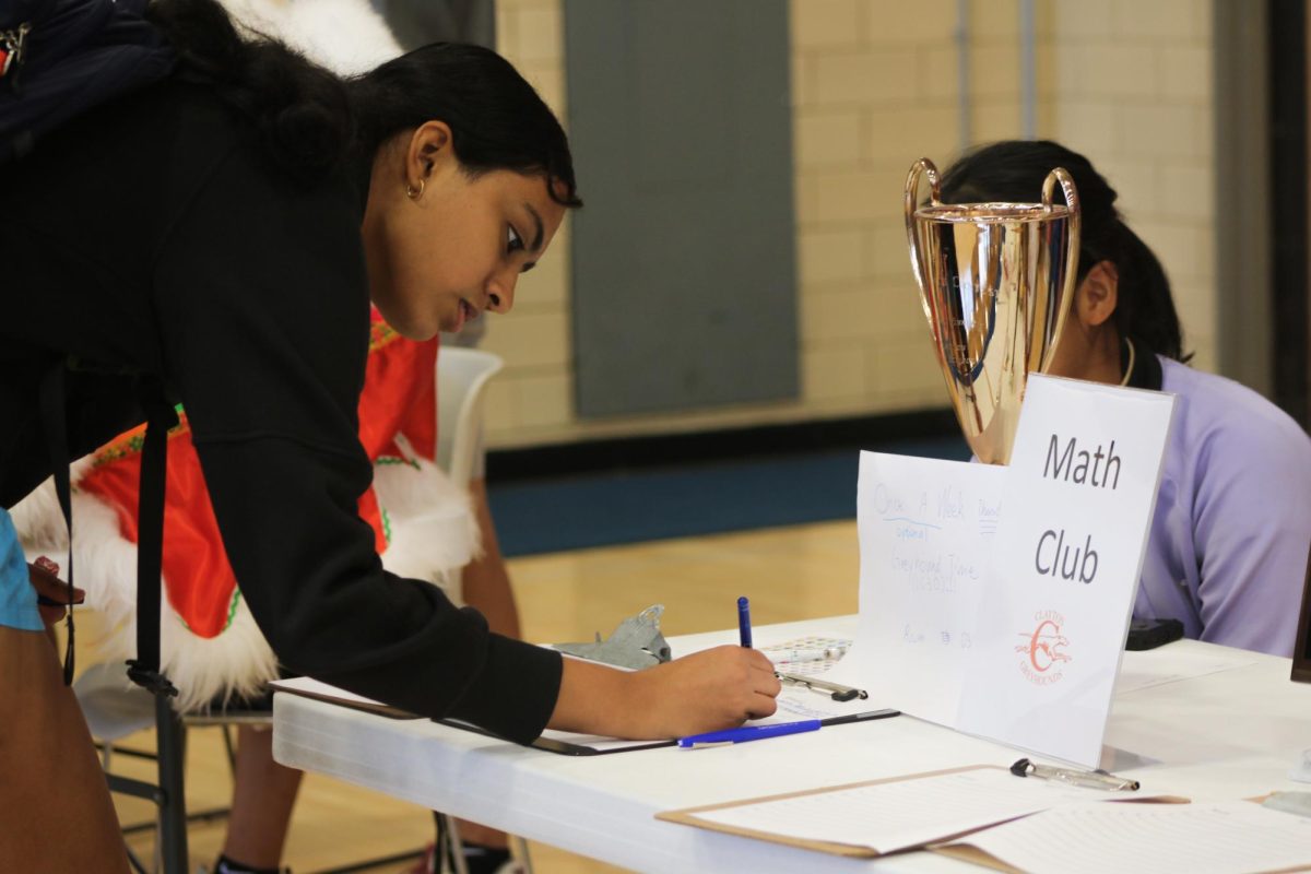 Freshman Sia Girivaru signs up to be a member at the Math Club booth.