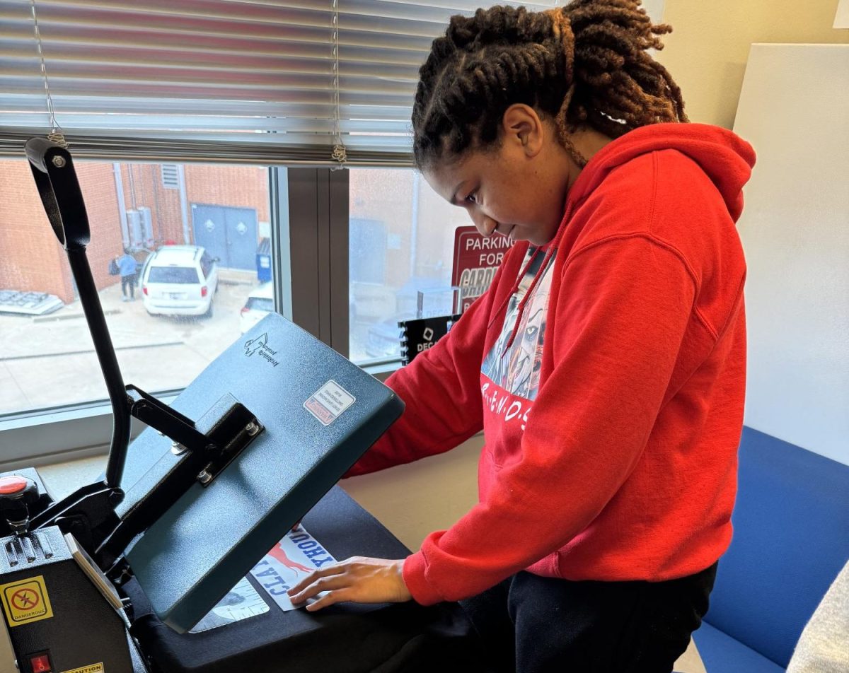 Senior Madison Nettles presses sweatshirts for the new merch store, Hound House, as a part of the Catalyst program. The business had a pop-up shop during lunch on Friday, Nov. 22. “Something I learned from the pop-up shop [was] that some of the teachers [and] staff asked for large sizes but we didn’t have any so next time we would need to keep that in mind so we can have more buyers,” Nettles said. “I think our supply met the students' demand. A lot of underclassmen [bought] our product.”